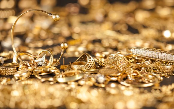 Table of scrap gold being inspected.Focal point on the two bracelets.